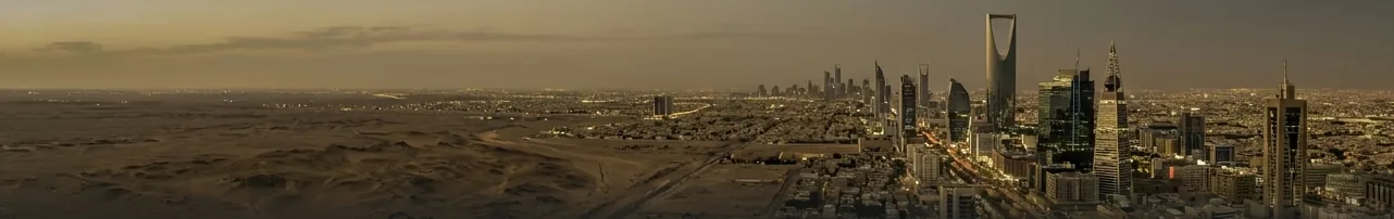 Riyadh skyline at dusk rising from the desert